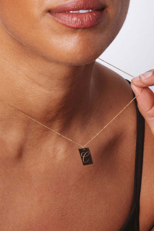 Stella Gold Initial Necklace – Personalized 14k Gold-Filled Pendant worn by a model showcasing the engraved initial 'C'.