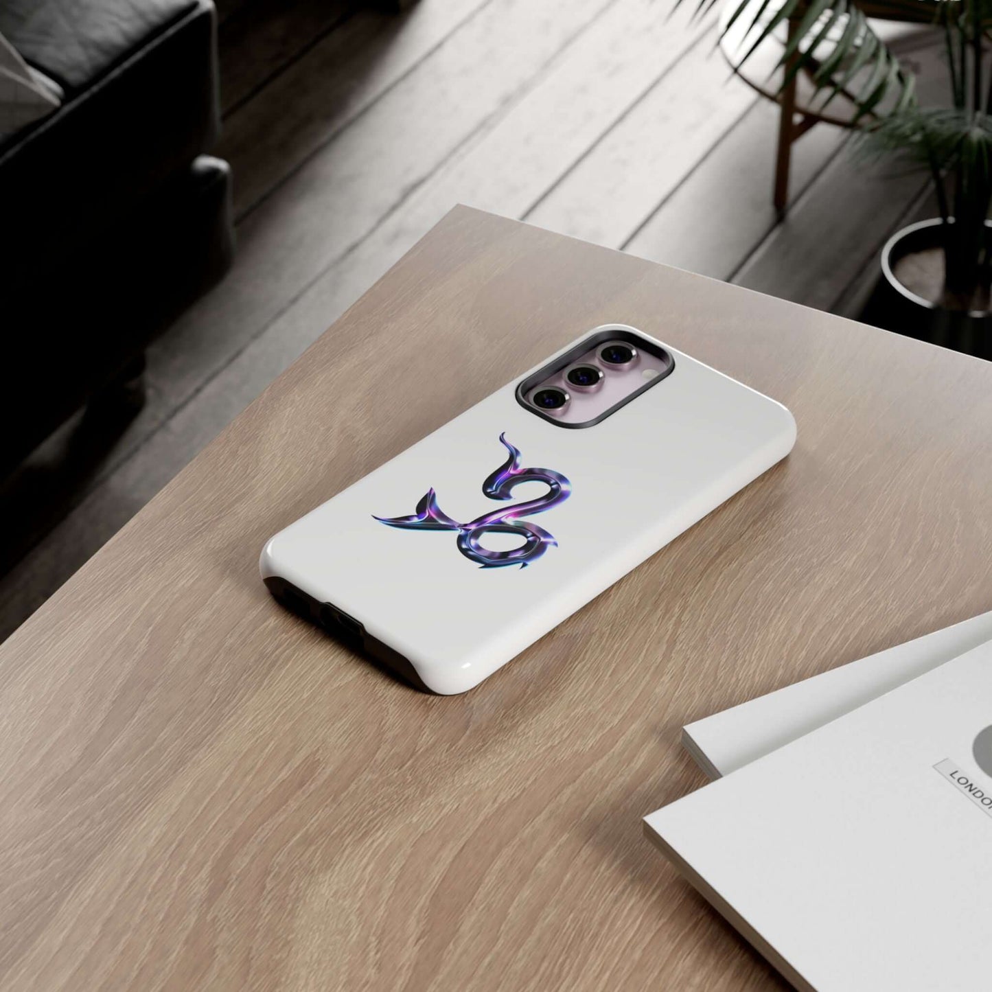 Personalized Zodiac phone case on a wooden table, showcasing a vibrant snake design and sleek white finish.