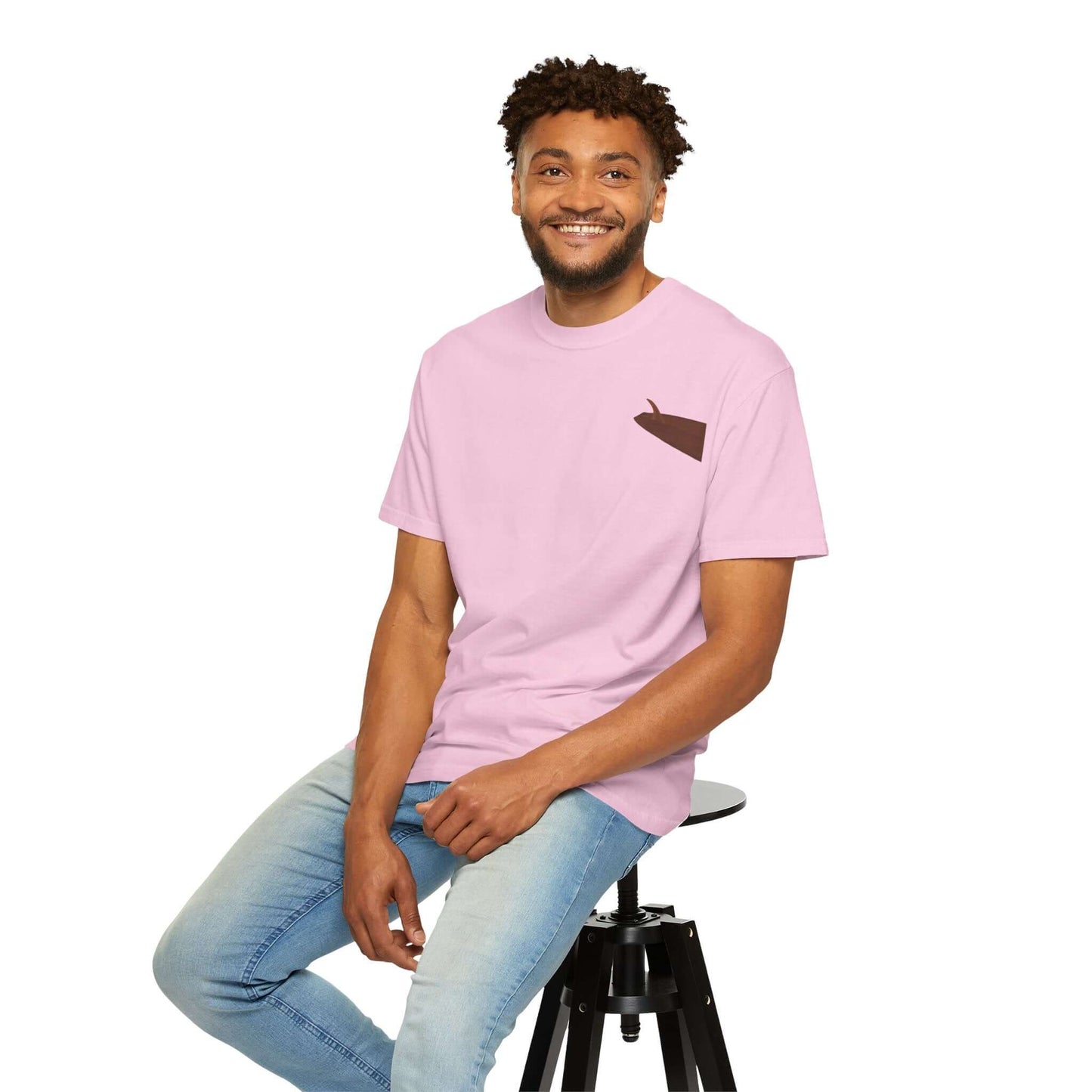 Personalized pink surf-inspired t-shirt featuring a unique design, worn by a smiling man seated on a stool.