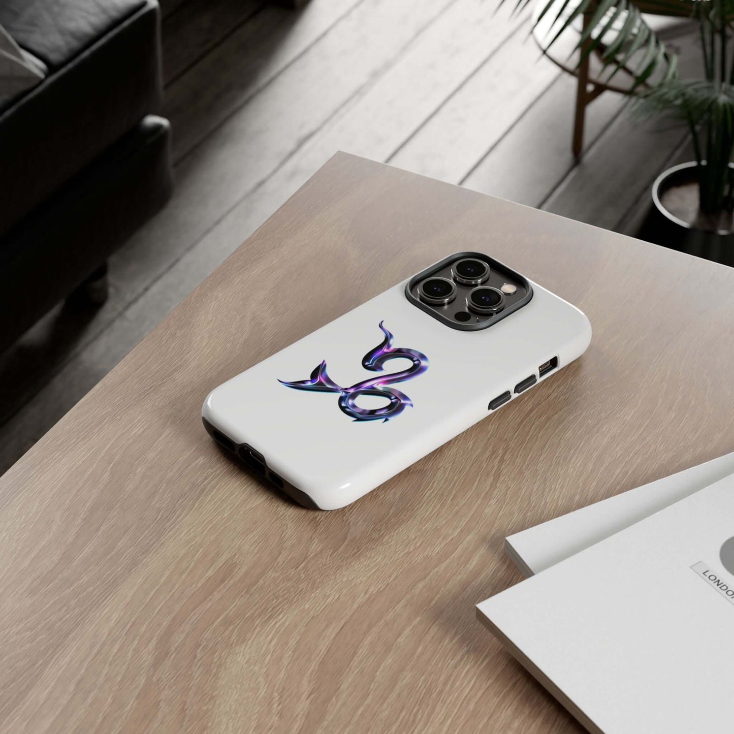 Personalized Zodiac phone case with vibrant design, showcasing star sign on a wooden table.