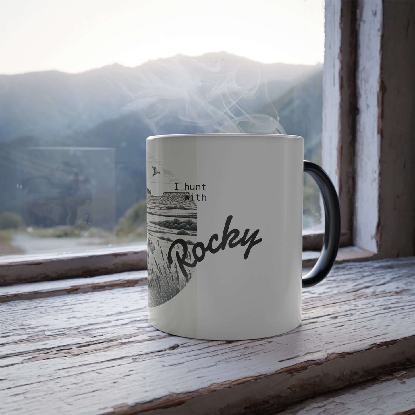 Personalized ceramic mug with 'I hunt with Rocky' text, set against a mountain view.