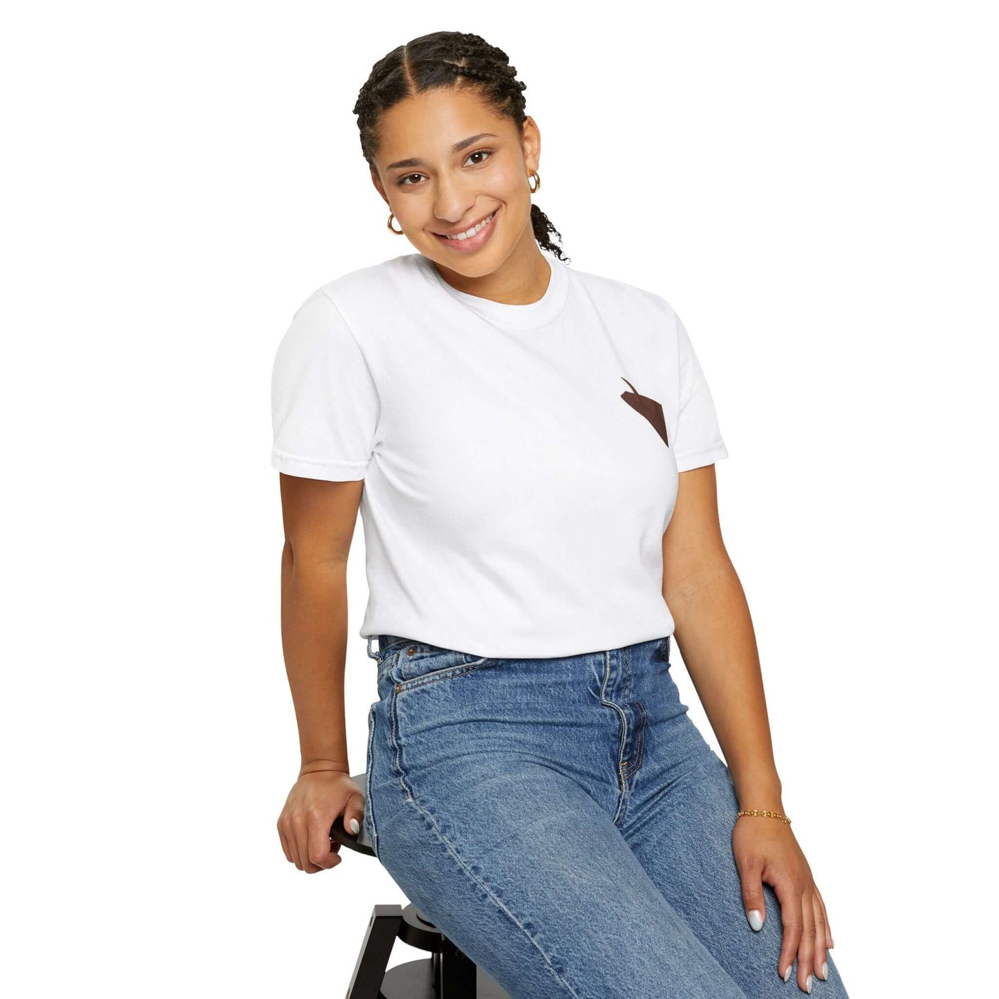 Model wearing a white personalized t-shirt with a brown pocket, smiling while sitting on a stool.