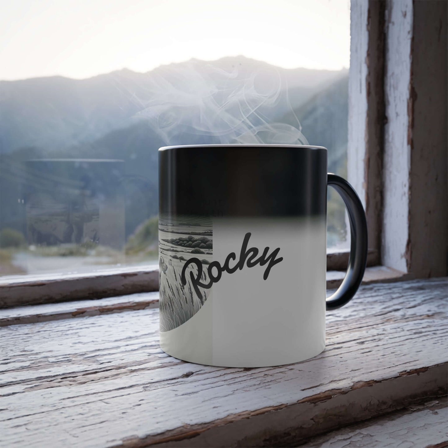 Personalized vintage heat-reactive coffee mug with 'Rocky' design, placed on a rustic window sill with mountains view.