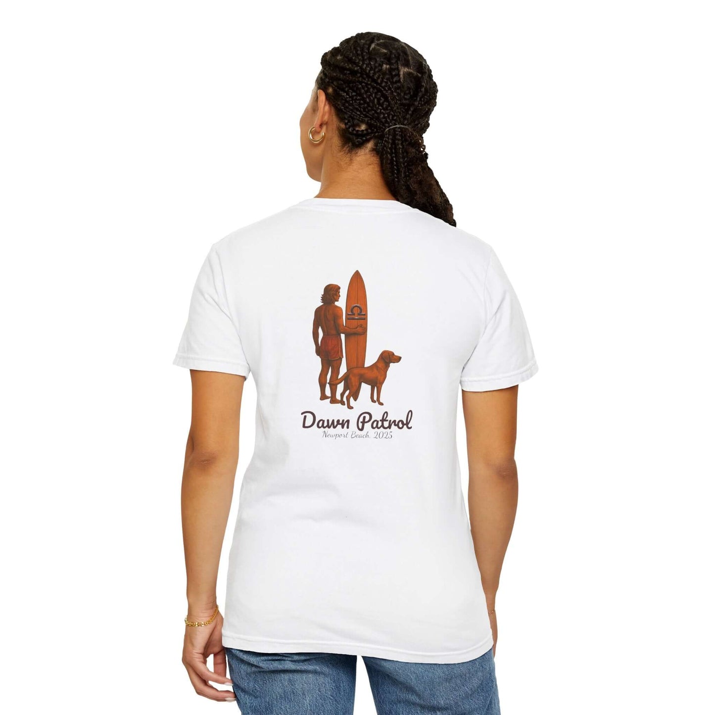 Person wearing a white t-shirt featuring a surf design and the text 'Dawn Patrol' with a dog and surfboard.