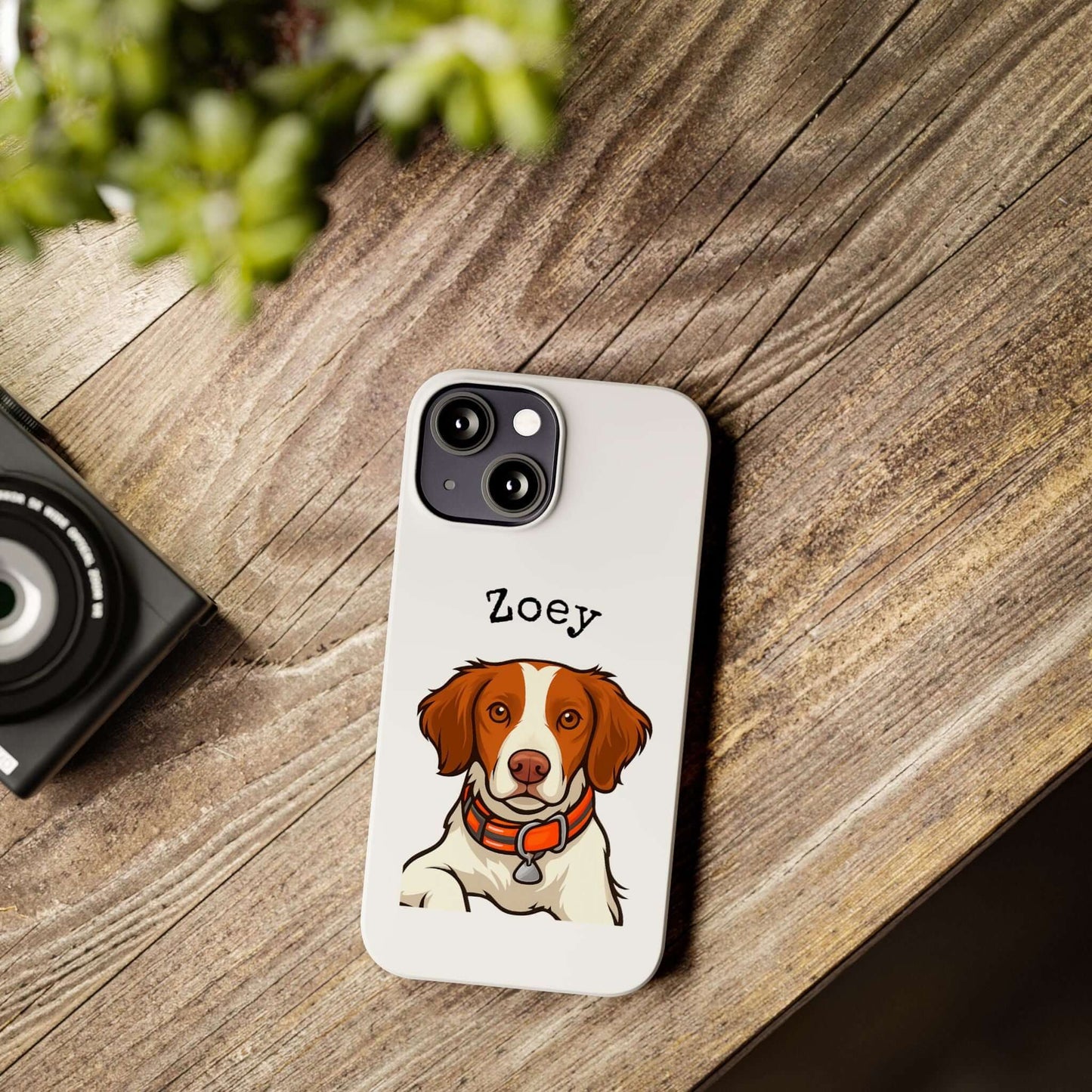 Custom dog cartoon phone case featuring a brown and white dog named Zoey on a wooden table.