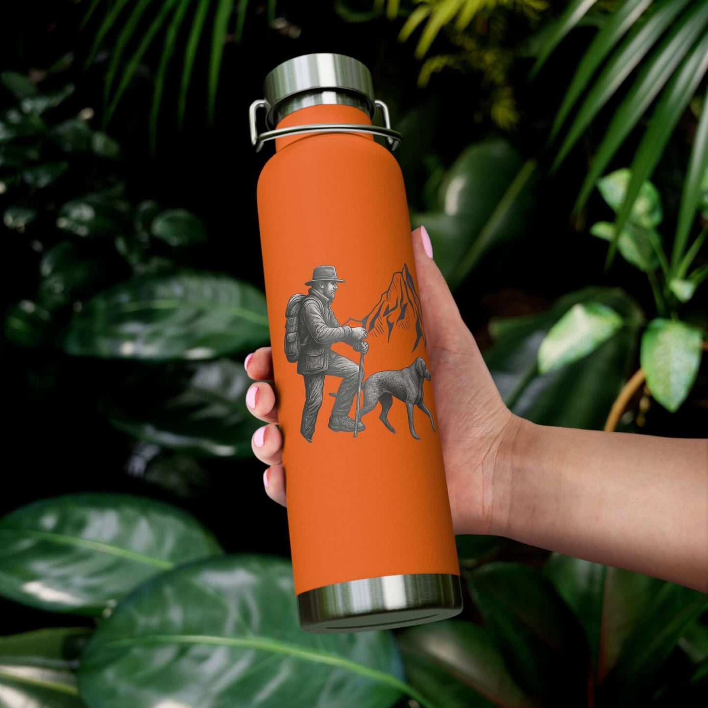 Personalized insulated hiking bottle with a mountain design held by a person in a lush green setting.