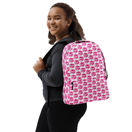 Girl wearing a stylish pink Pack & Play Backpack, showcasing its playful pattern and sporty design.