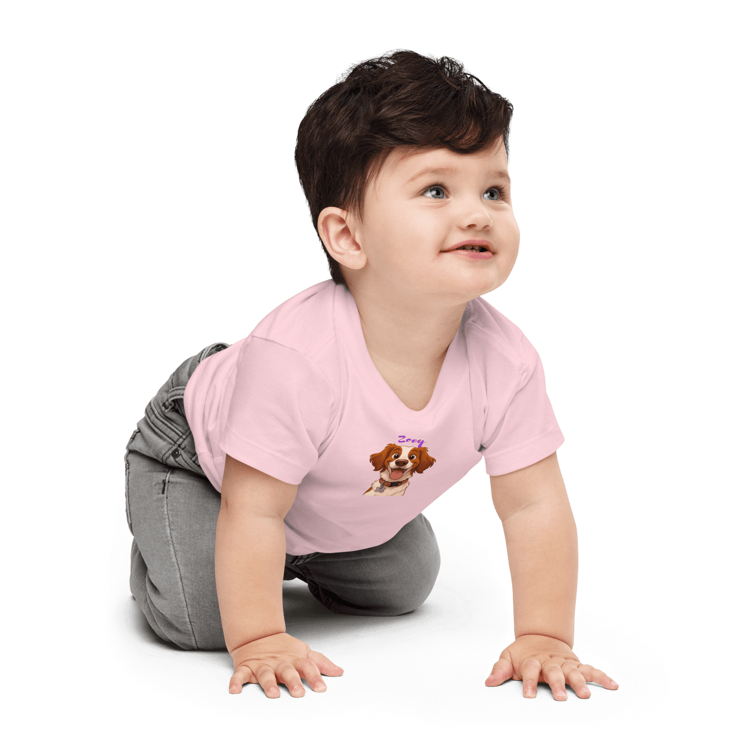 Baby wearing pink tee featuring custom cartoon dog design, smiling while crawling.