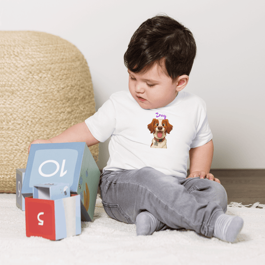 Toddler wearing a custom cartoon pet baby tee featuring a dog named Zerzy, playing with colorful blocks.