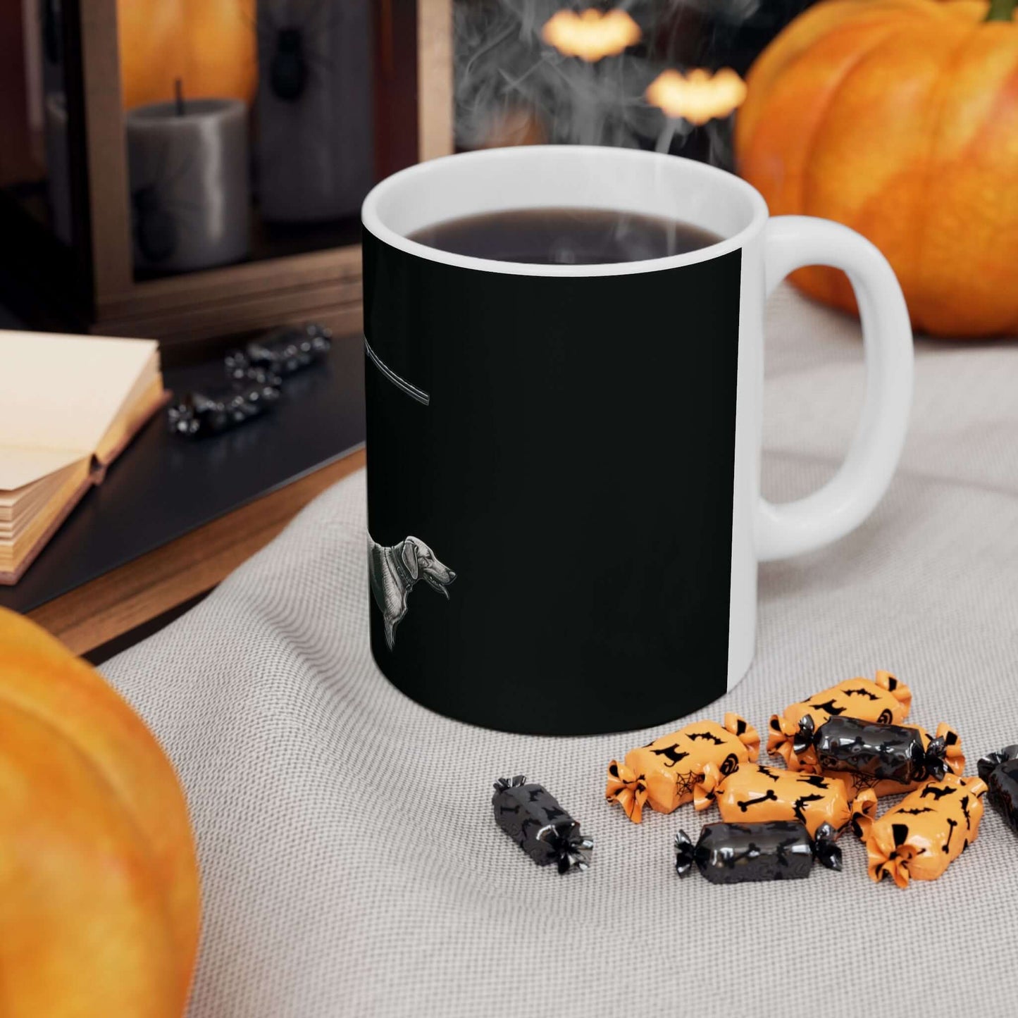 Personalized black hunting mug next to Halloween decorations and candies, perfect for outdoor enthusiasts.