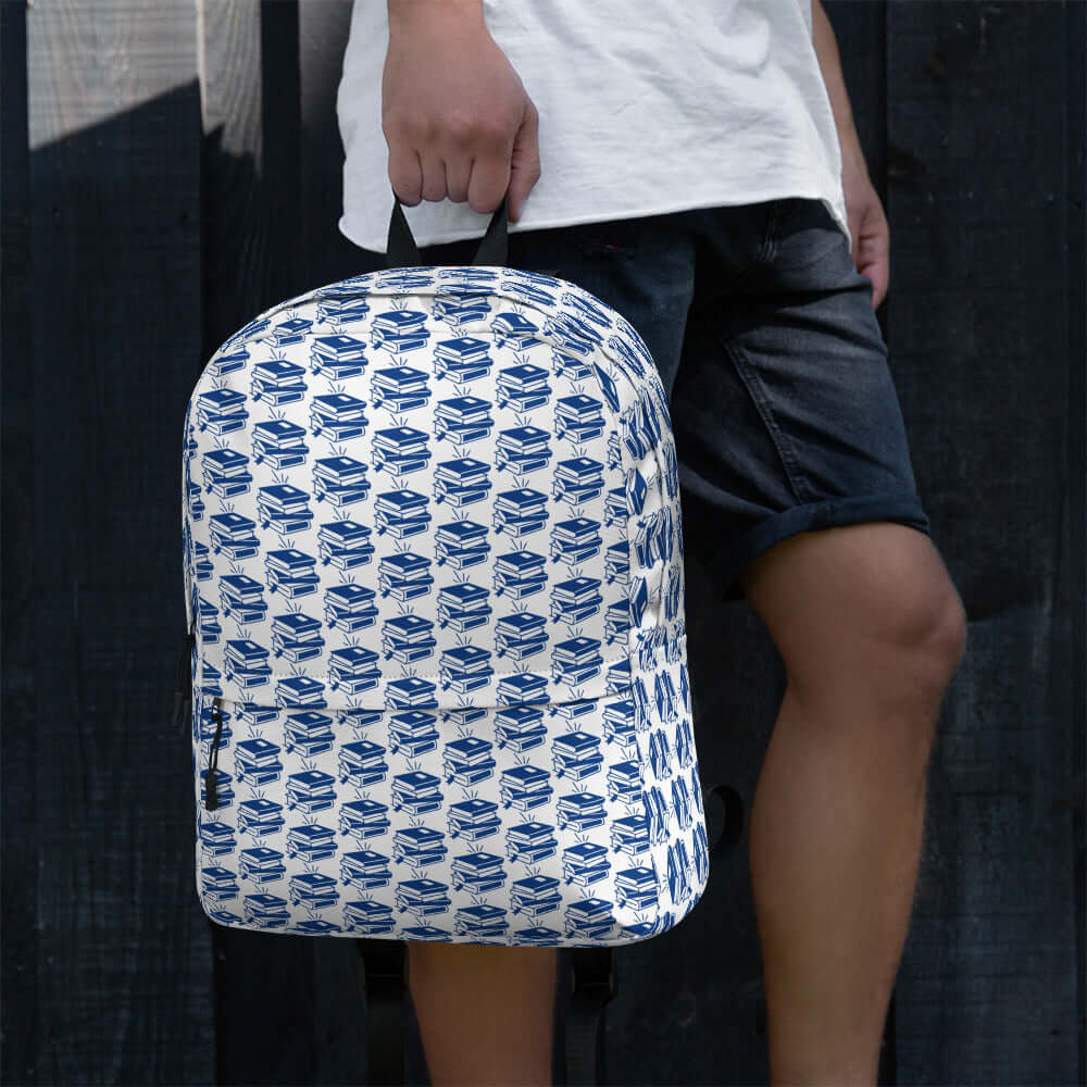 Bookish backpack with geometric book pattern, perfect for students and creatives, worn by a person.