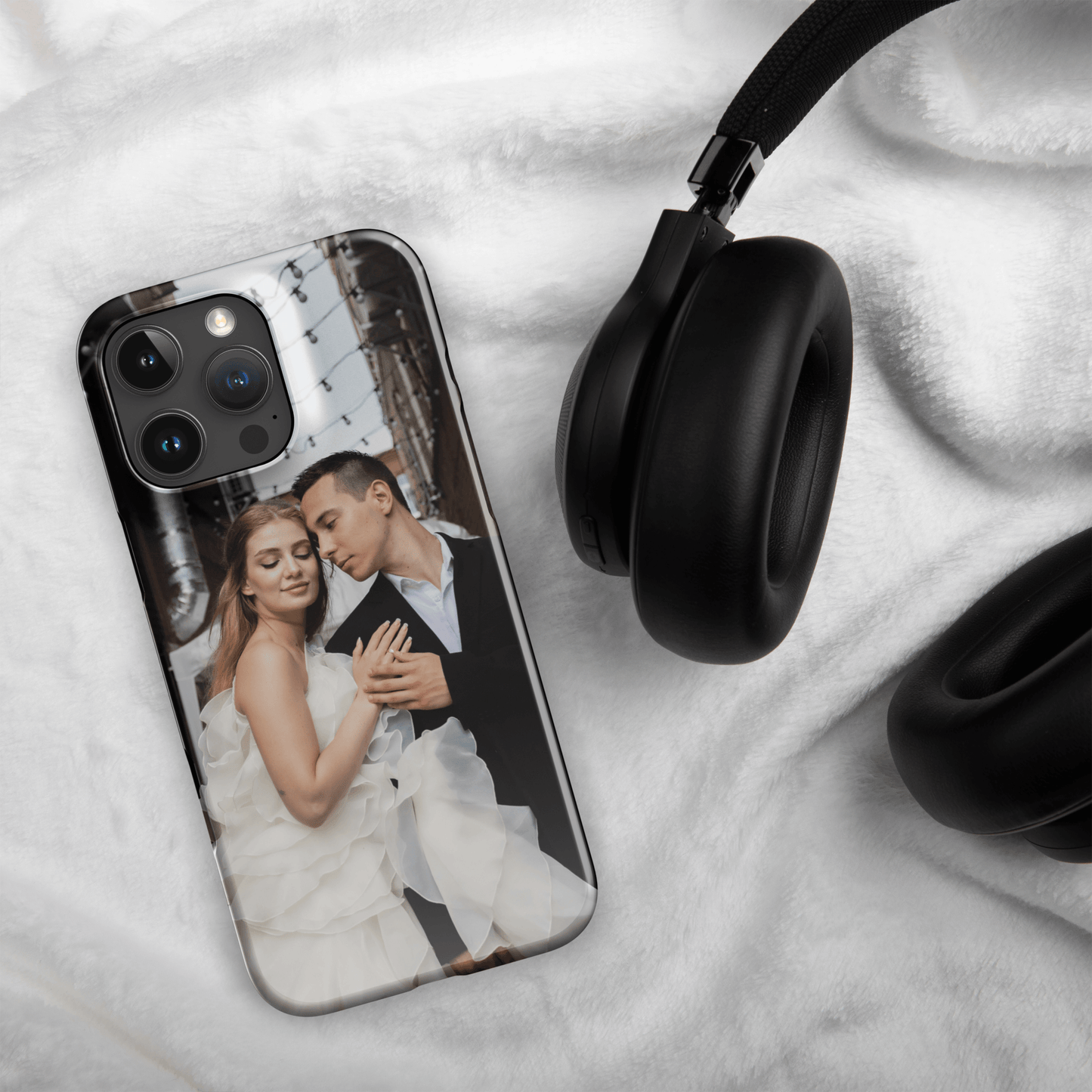 Custom iPhone case featuring a romantic couple photo, showcasing a stylish design next to black headphones.
