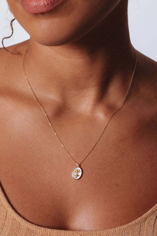 Model wearing Katrina Birth Flower Necklace – Gold-Filled & Mother of Pearl showcasing the elegant oval pendant.