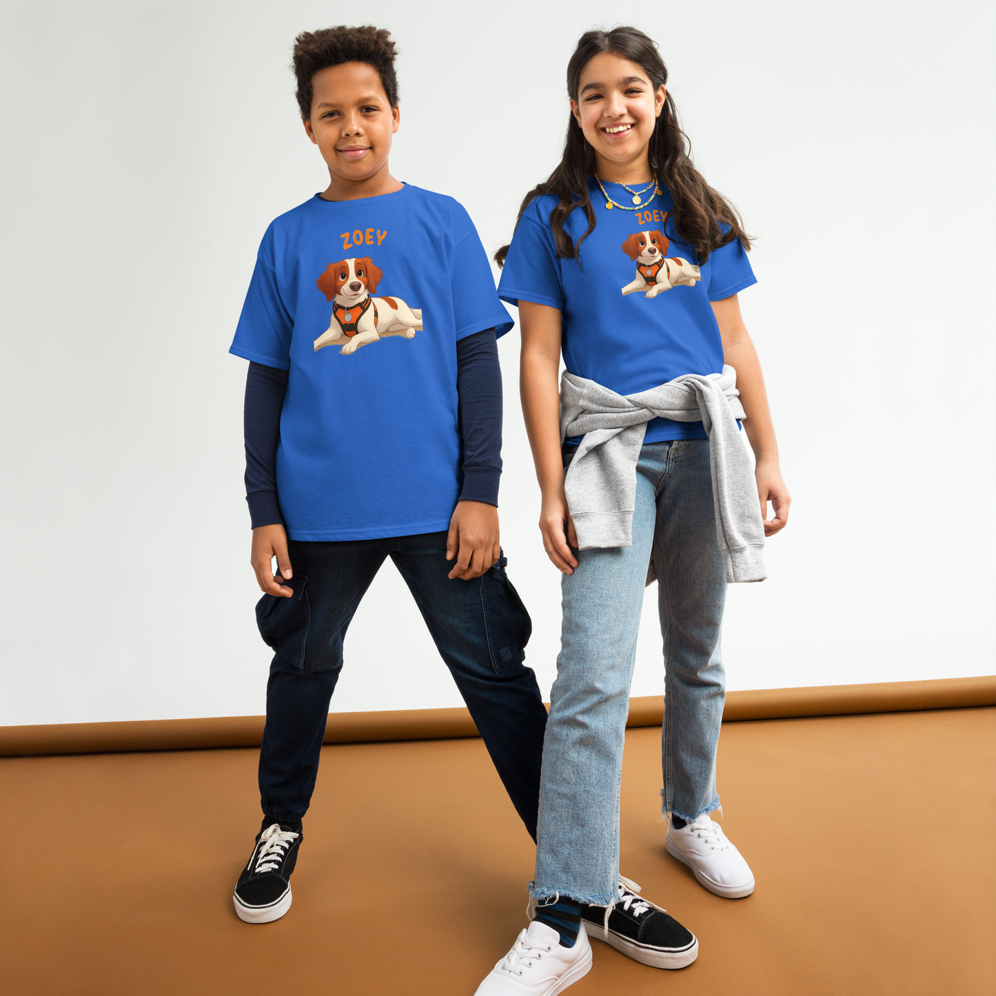 Kids wearing personalized cartoon pet shirts with a dog illustration and custom names, smiling in blue tees.