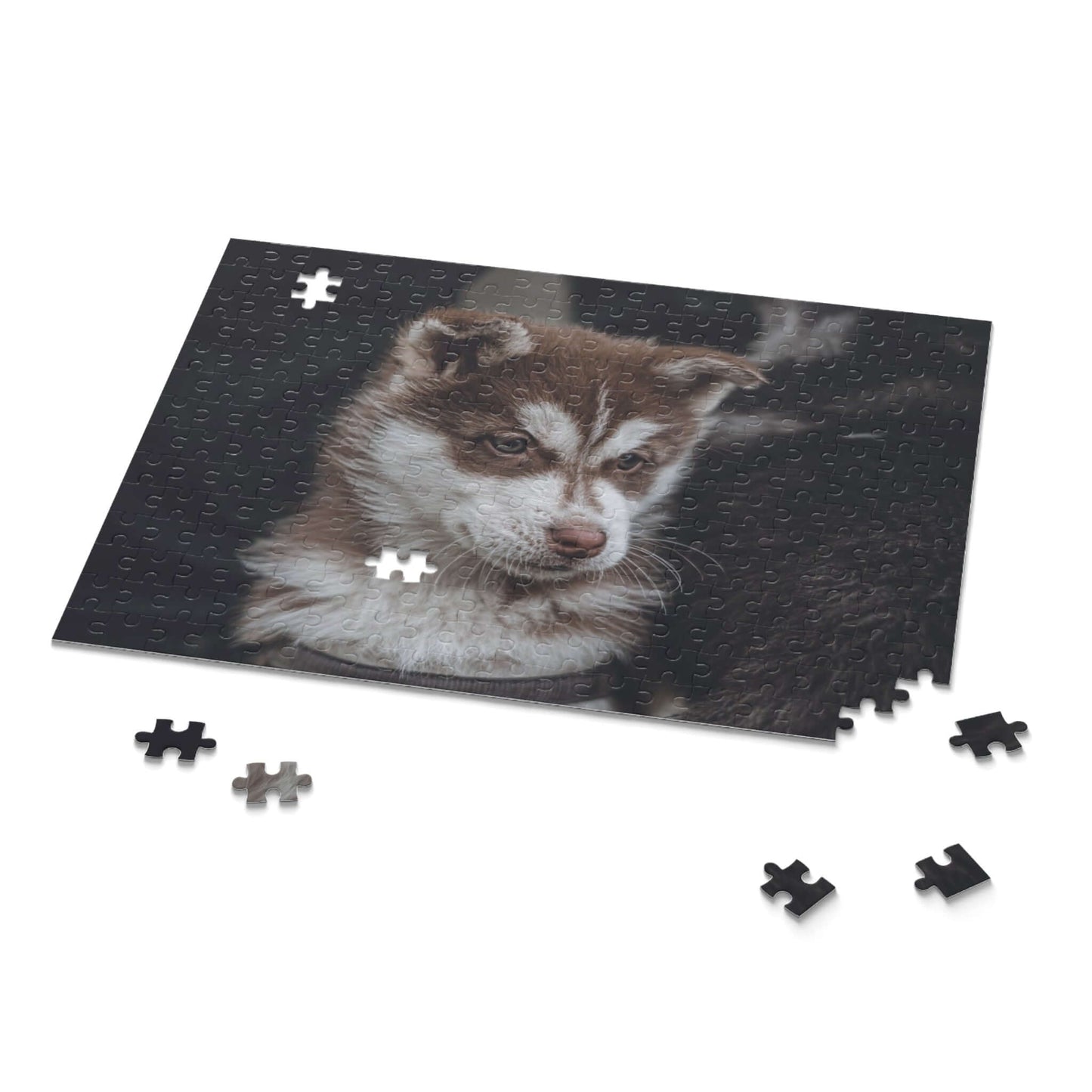 A partially completed puzzle featuring an adorable husky puppy, surrounded by scattered pieces.