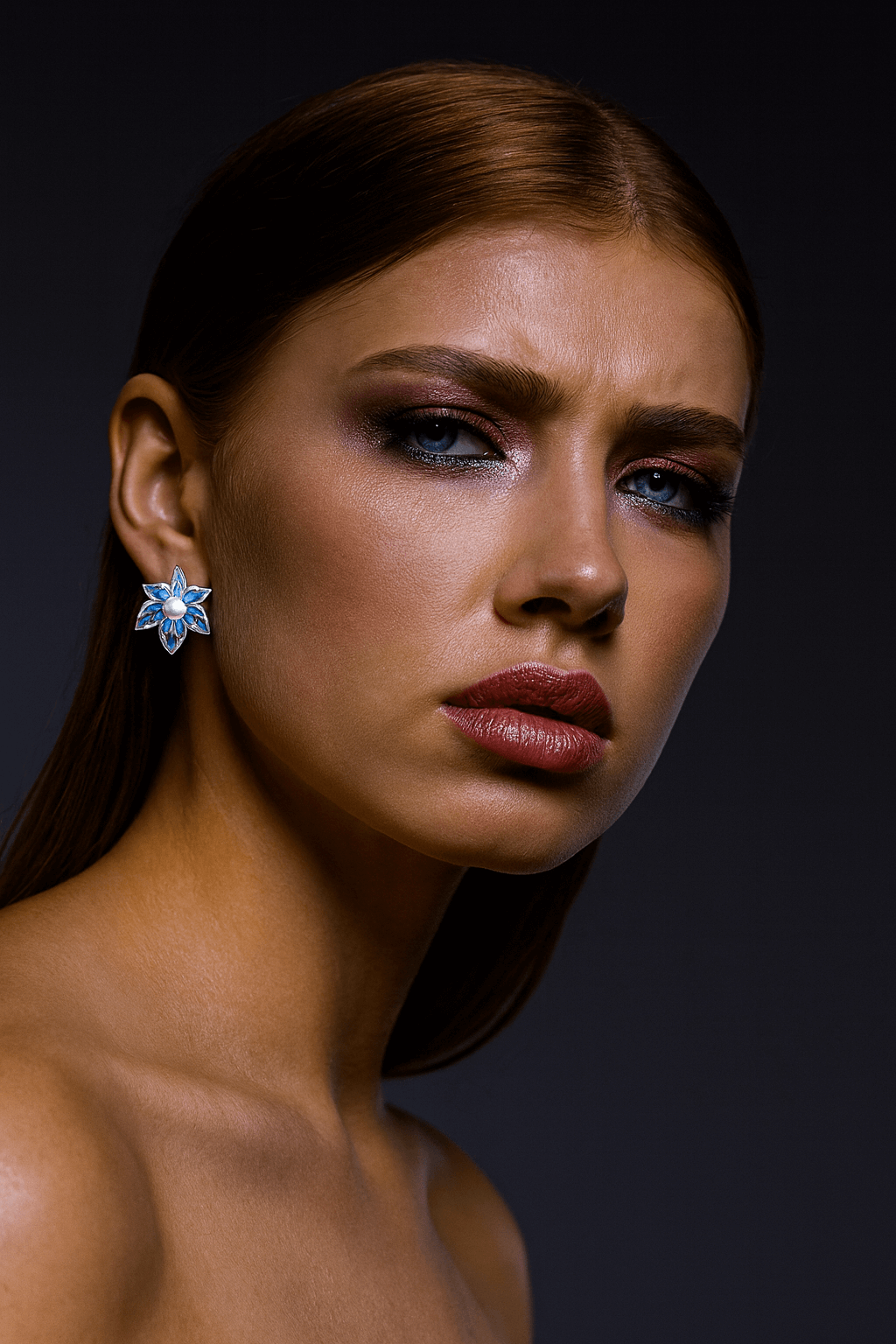 Statement Flower Earrings with Denim Petals and Pearl Centers worn by a model with bold makeup.