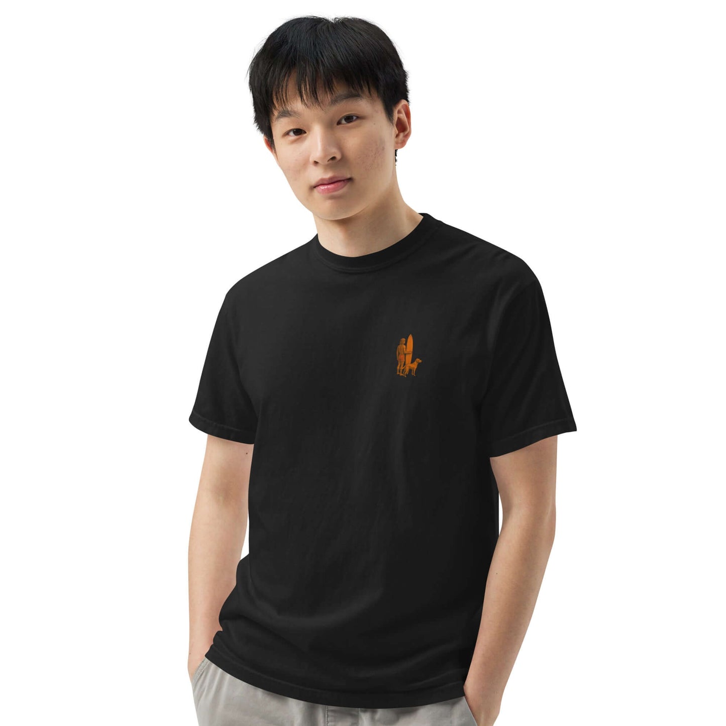 Young man wearing a black Surf Sunset Heavyweight Tee with a minimalist surfer and dog design.