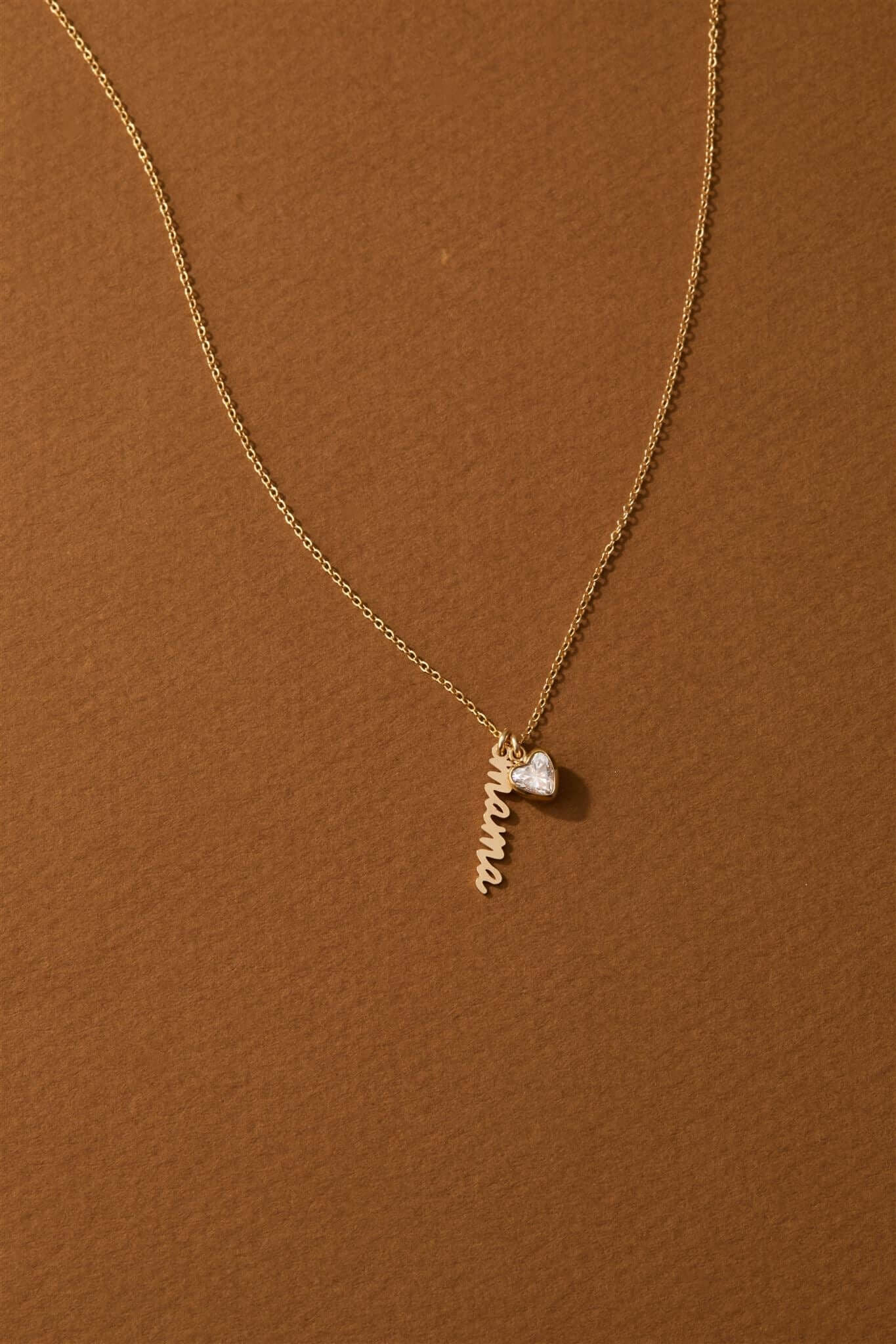 Vivienne Mama Necklace – Gold-Filled Charm & CZ Heart with a delicate charm and heart-shaped cubic zirconia on a gold chain.