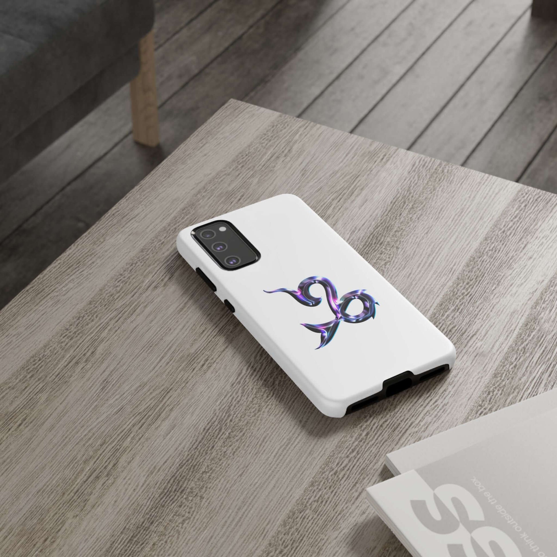 Personalized Zodiac phone case with vibrant Capricorn design on a wooden table, showcasing stylish cosmic flair.