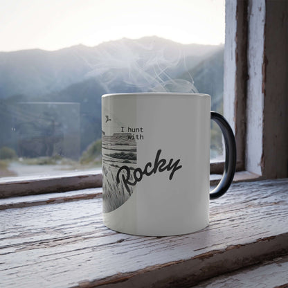 Personalized ceramic mug with 'I hunt with Rocky' text, set against a mountain view.