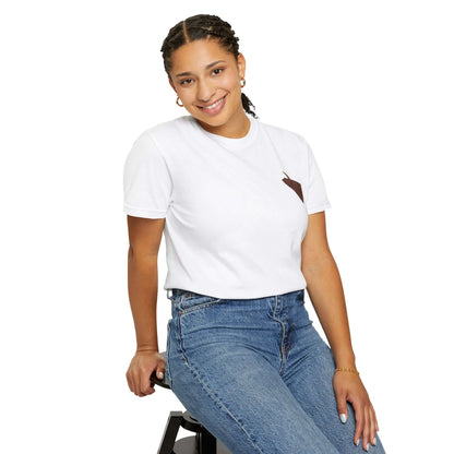 Model wearing a white personalized t-shirt with a brown pocket, smiling while sitting on a stool.