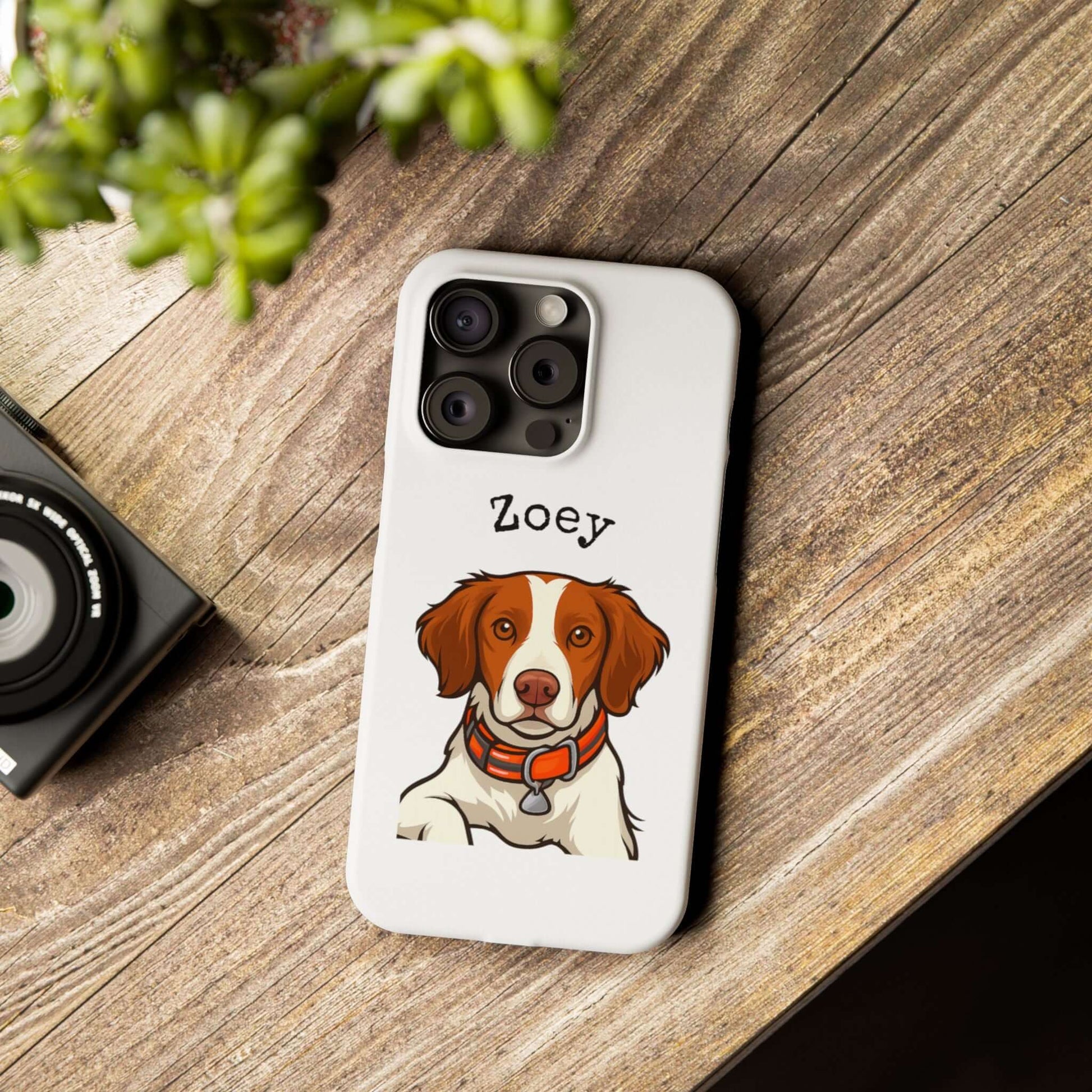 Custom cartoon phone case featuring a dog illustration named Zoey on a wooden surface.