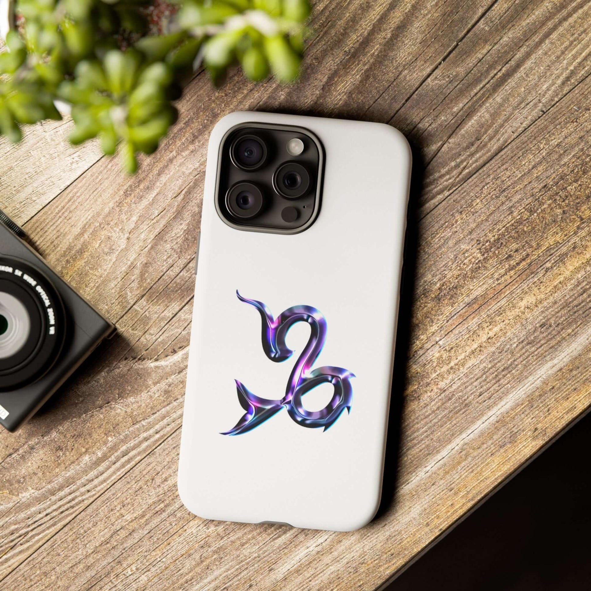 Personalized Zodiac phone case with colorful Capricorn design on a wooden table, showcasing individuality and style.