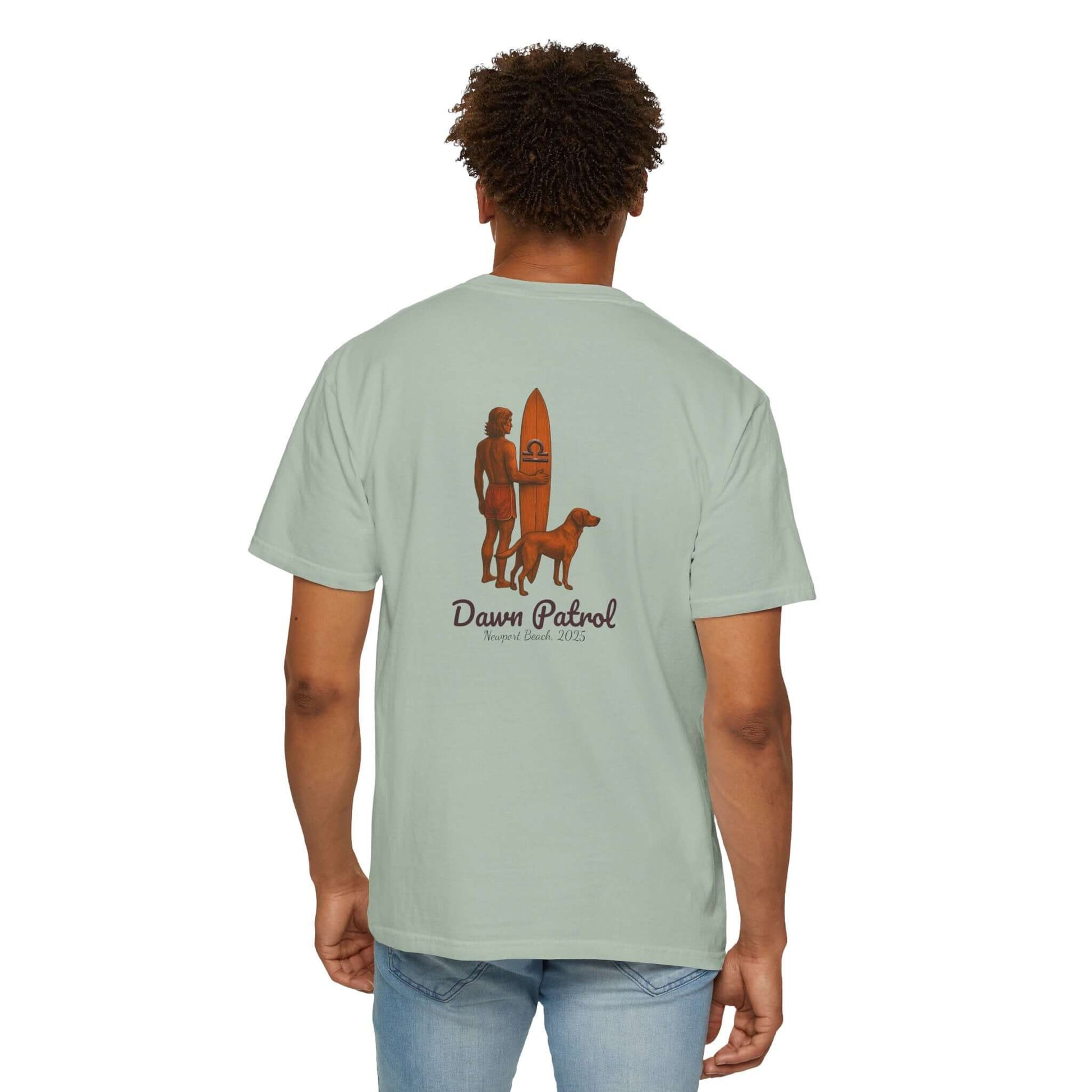 Man wearing a mint green personalized t-shirt with a retro surf design and the text 'Dawn Patrol' on the back.