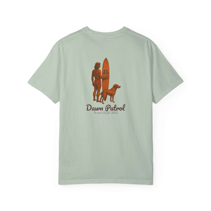 Light green t-shirt featuring a person with a surfboard and a dog, labeled 'Dawn Patrol'.