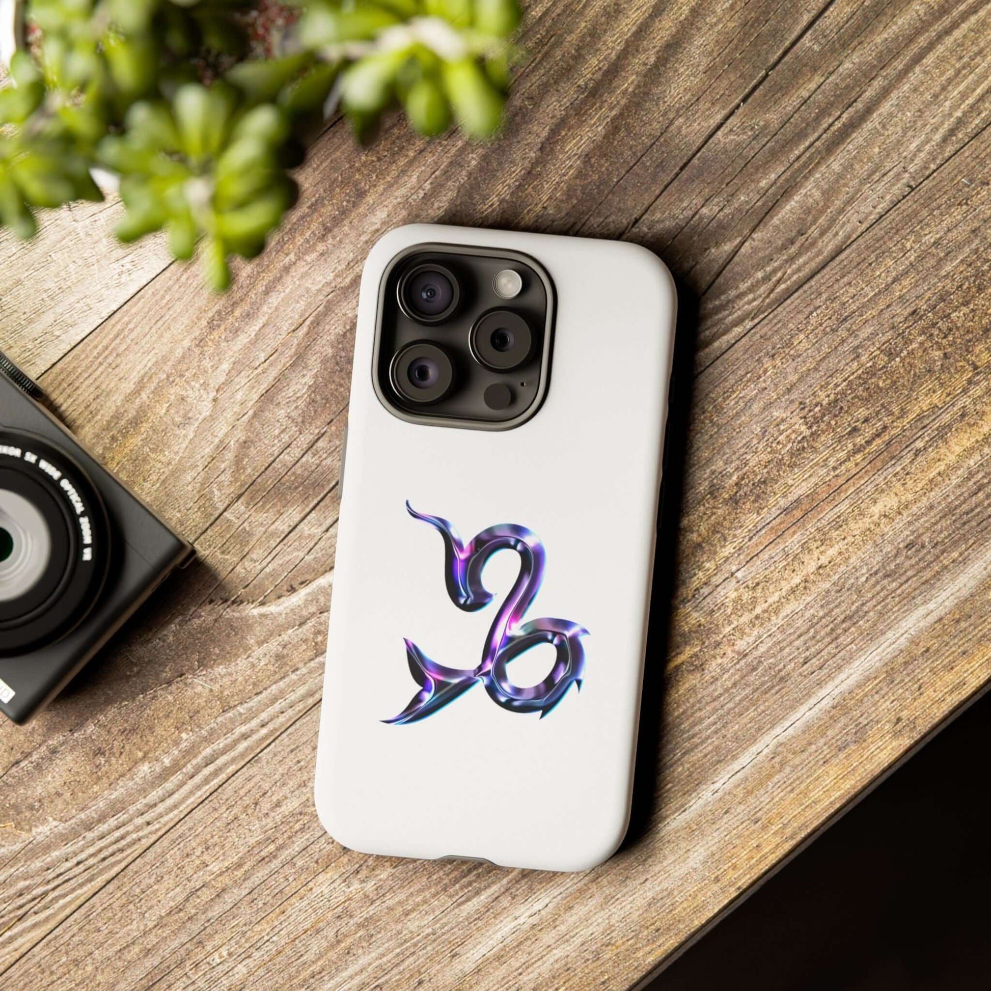 Stylish personalized zodiac phone case featuring a colorful Capricorn design on a wooden surface.
