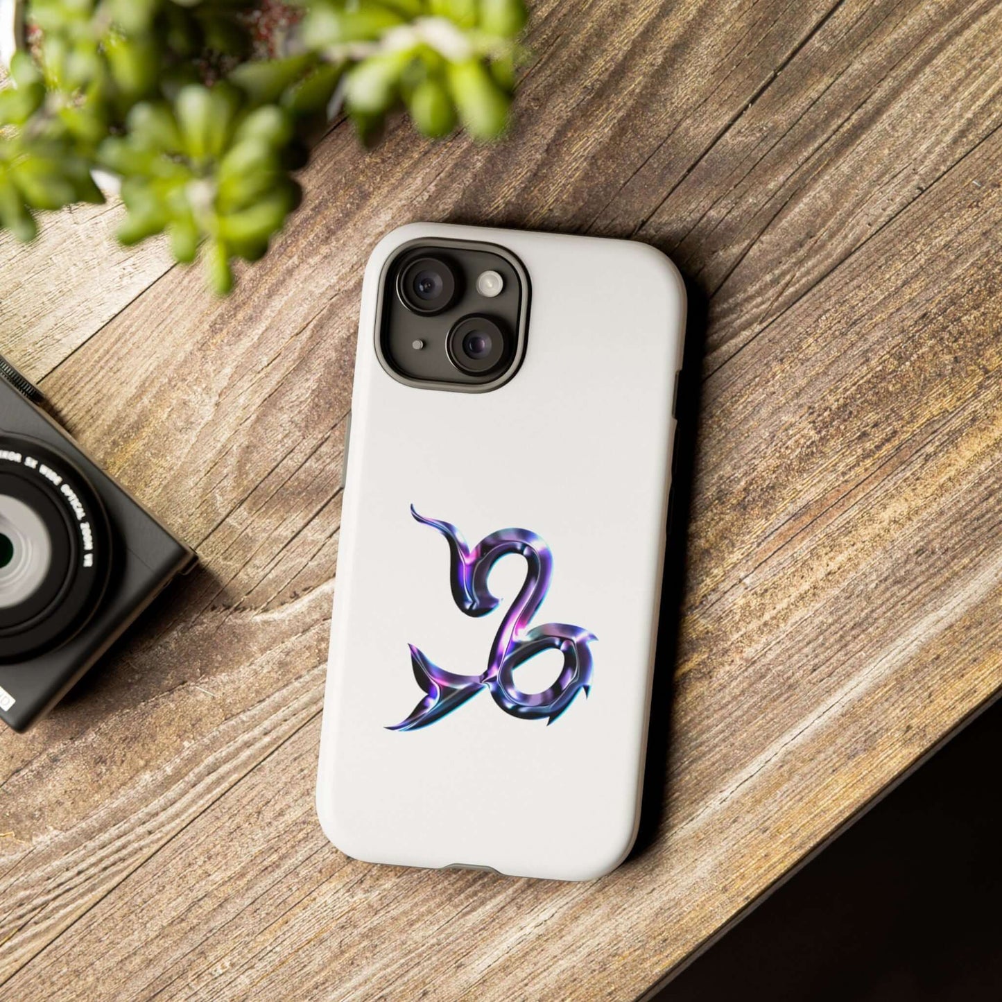 Personalized Zodiac phone case with vibrant Capricorn design on a wooden table.