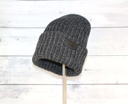 Adult Acrylic Ribbed Cuff Hat – Classic Warmth with Purpose on display against a rustic wooden background.