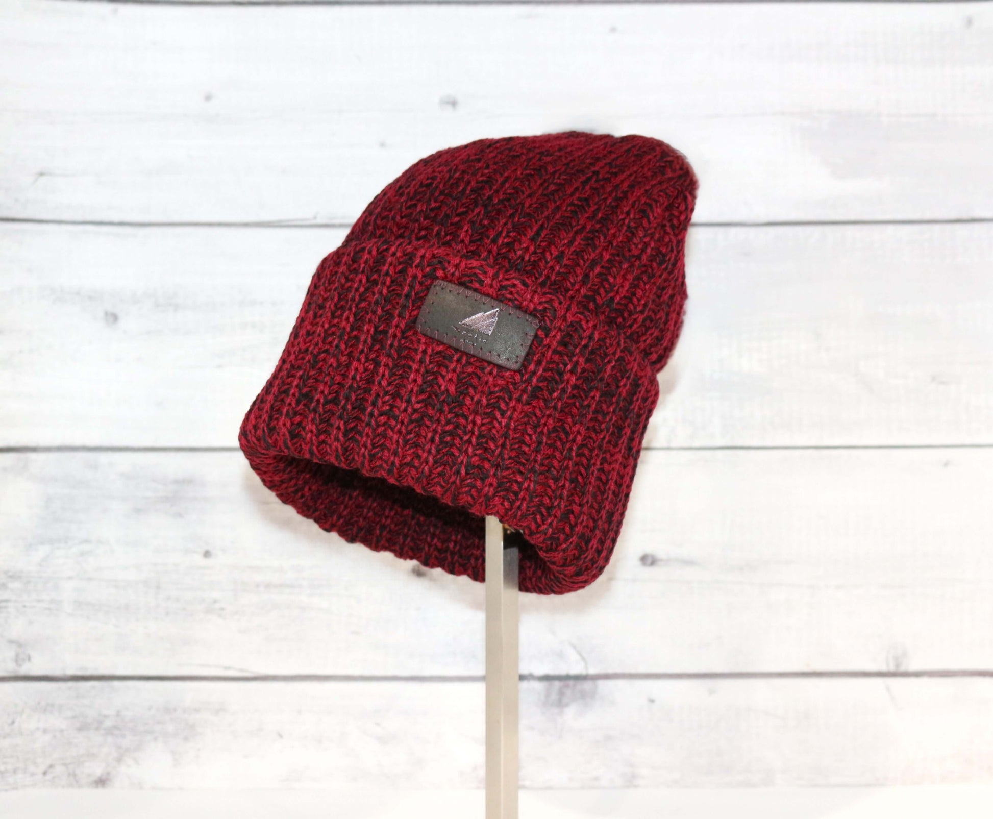 Adult Acrylic Ribbed Cuff Hat – Classic Warmth with Purpose displayed in burgundy color on a stand.
