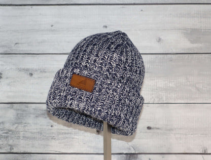 Child Acrylic Ribbed Cuff Hat – Soft, Stretchy & Purposeful displayed on a stand, featuring a cozy knitted design.