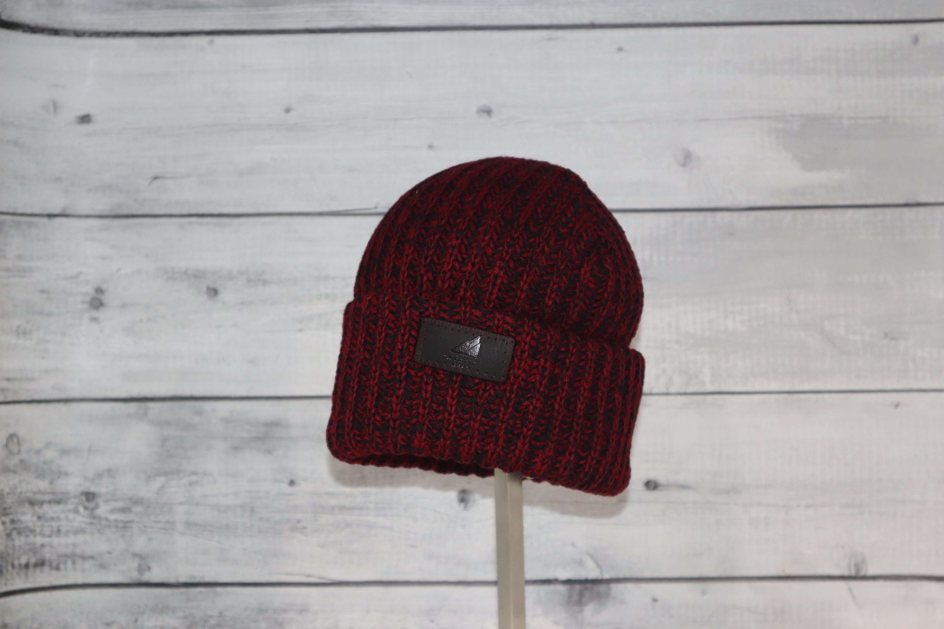 Child Acrylic Ribbed Cuff Hat – Soft, Stretchy & Purposeful in maroon color on a display stand.