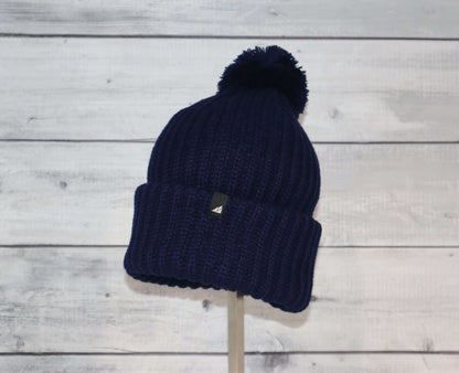 Child Acrylic Ribbed Cuff Hat with Pom – Cozy, Playful, Purposeful on display with a navy color.