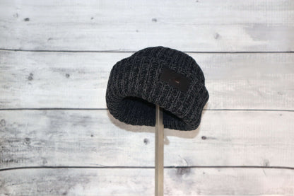 Infant Acrylic Ribbed Cuff Hat – Soft, Stretchy & Purposeful displayed on a stand against a wooden background.