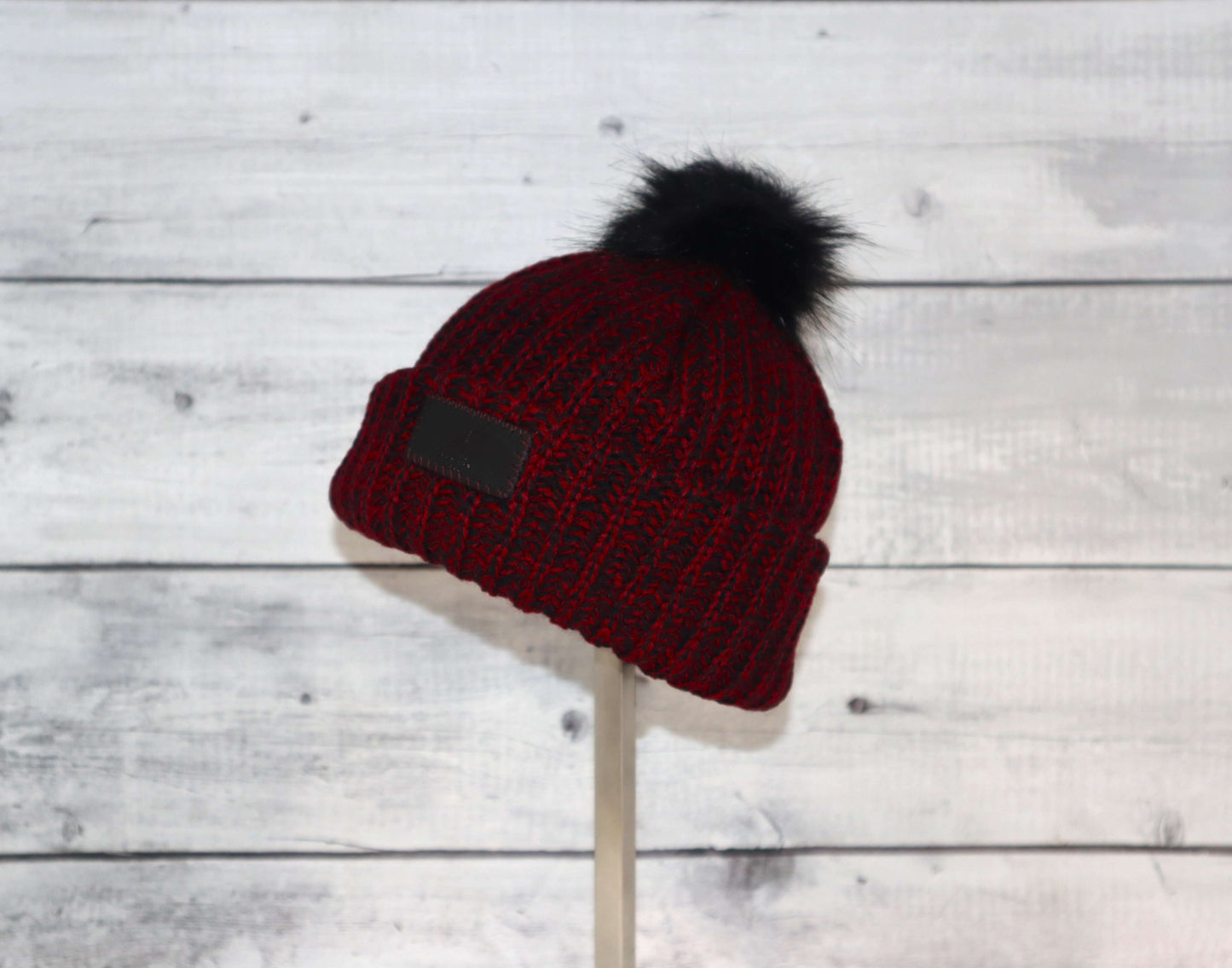 Infant Acrylic Ribbed Cuff with Pom Hat – Cozy & Purposeful in red with a black pom on top, perfect for cold weather.