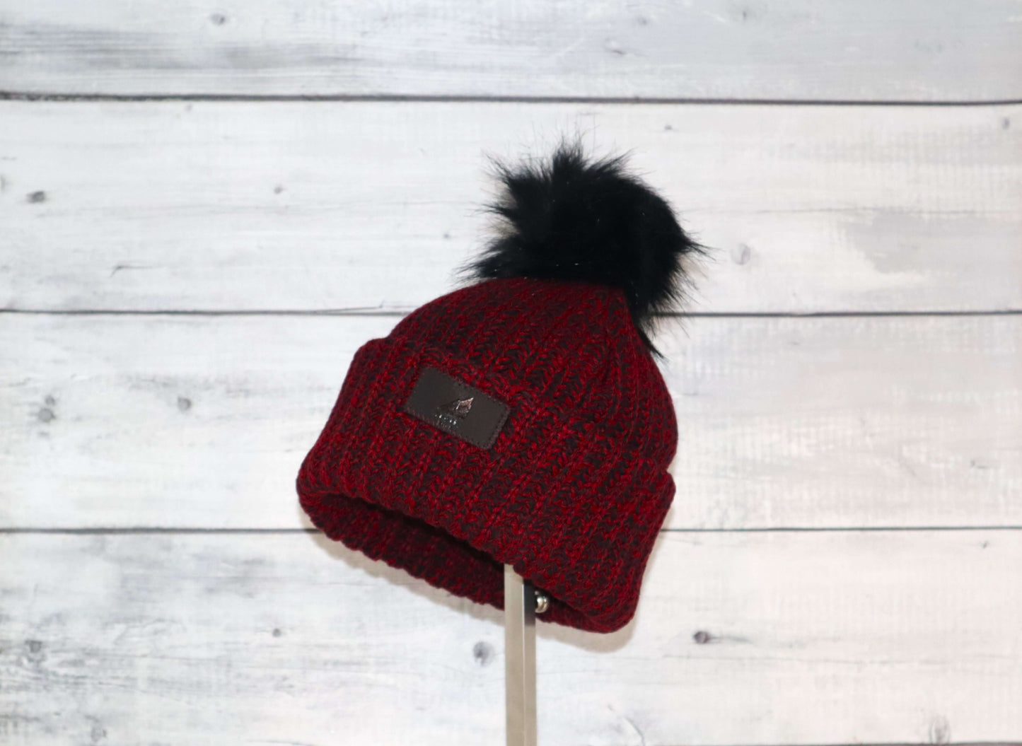 Toddler Acrylic Ribbed Cuff with Pom Hat – Cozy & Purposeful displayed on wood background.