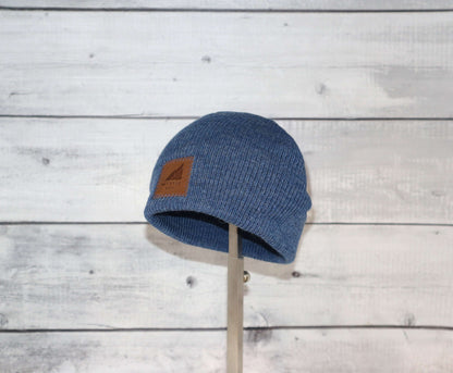 Toddler Acrylic Wool Beanie – Soft, Stretchy & Winter-Ready in blue color on display against a wooden background.