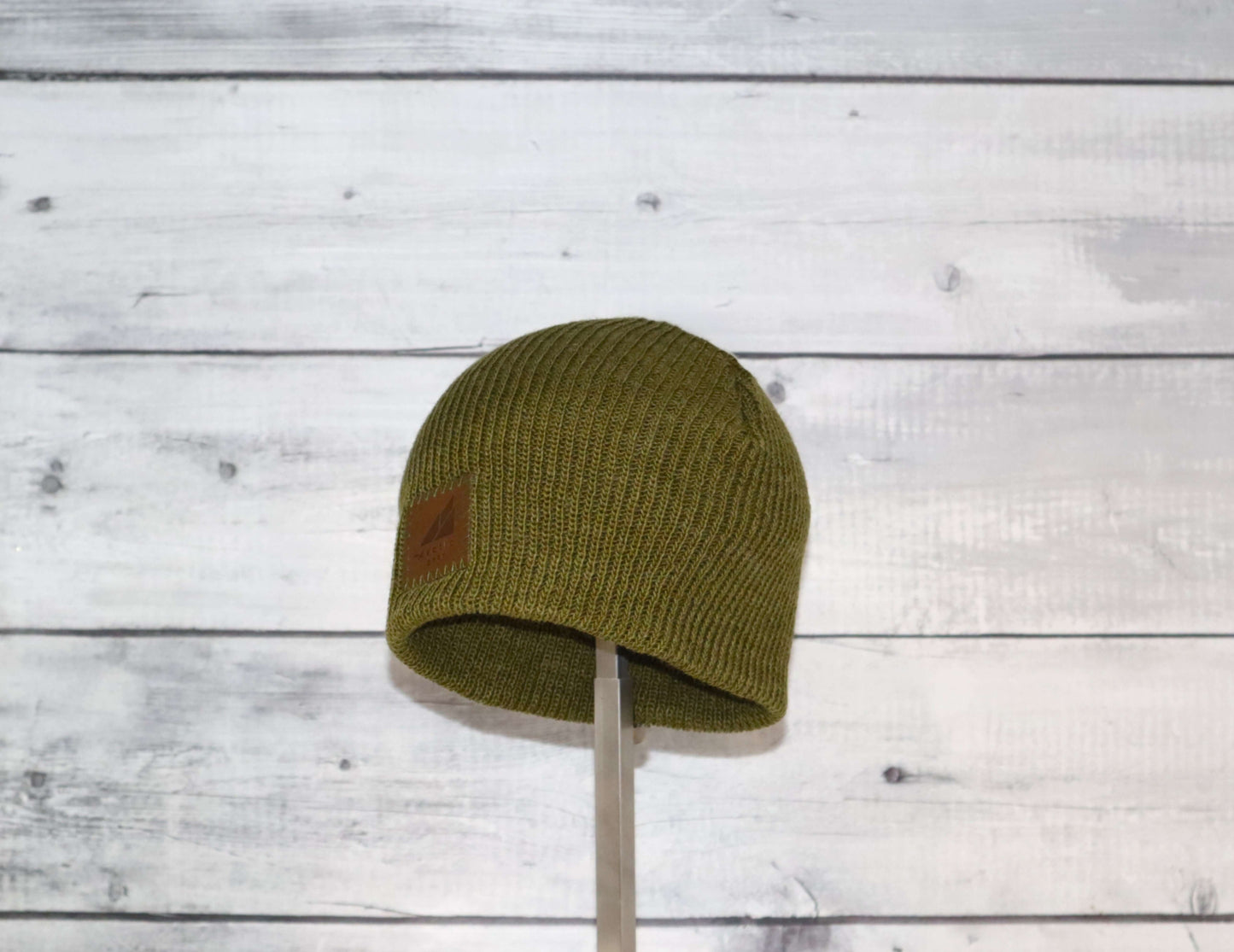 Toddler Acrylic Wool Beanie – Soft, Stretchy & Winter-Ready in olive green color against a rustic wood background.