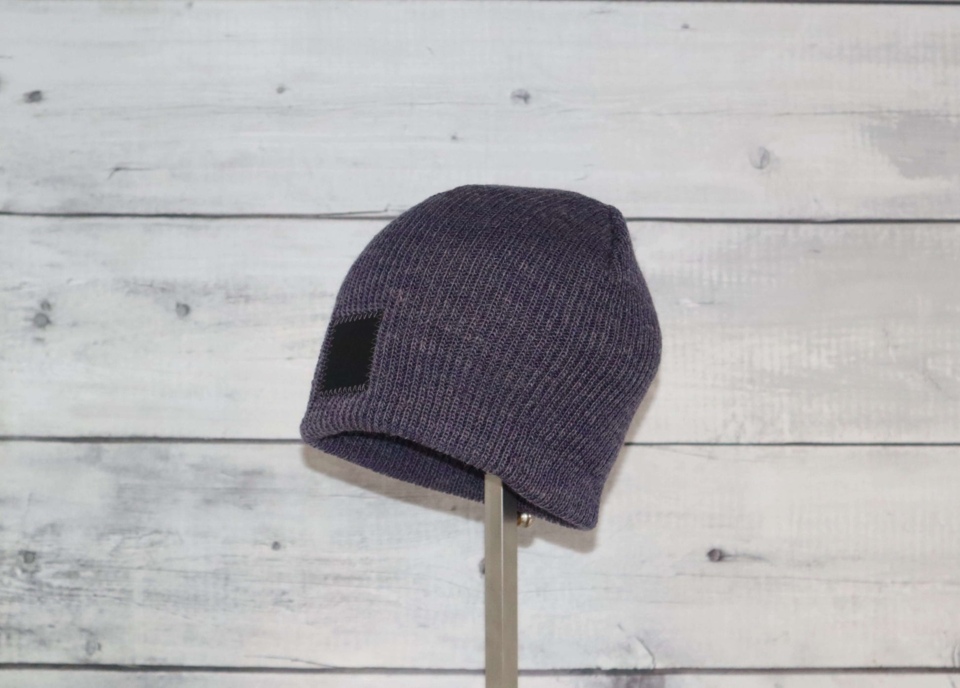 Toddler Acrylic Wool Beanie – Soft, Stretchy & Winter-Ready displayed on a stand with a rustic wooden background.