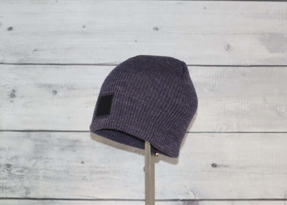 Toddler Acrylic Wool Beanie – Soft, Stretchy & Winter-Ready displayed on a stand with a rustic wooden background.