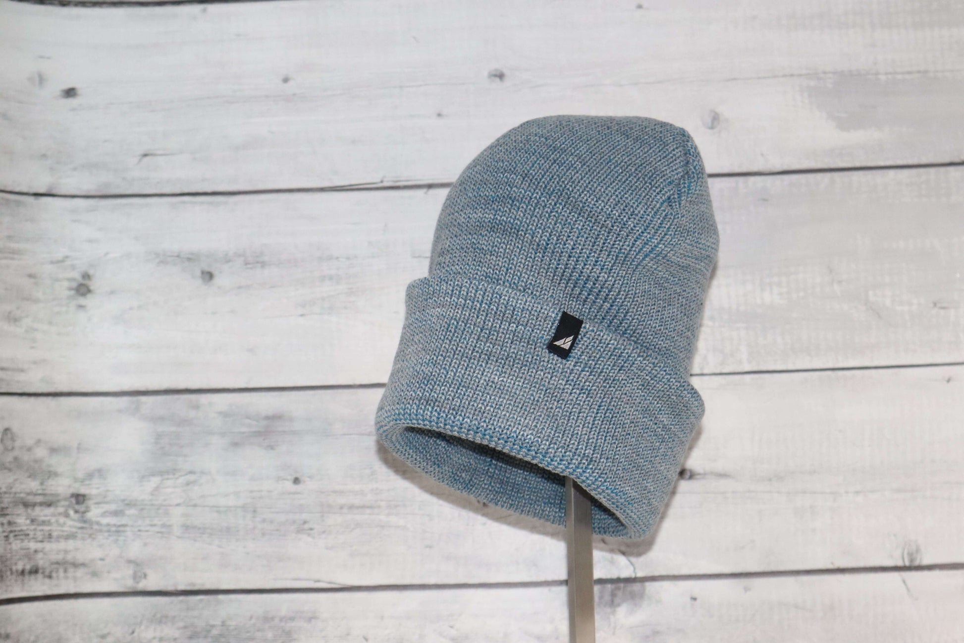 Adult Acrylic Cuff Hat – Soft Knit Beanie on a wooden background, showcasing its soft material and snug fit.