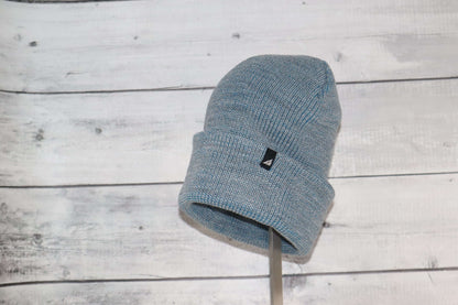 Adult Acrylic Cuff Hat – Soft Knit Beanie on a wooden background, showcasing its soft material and snug fit.