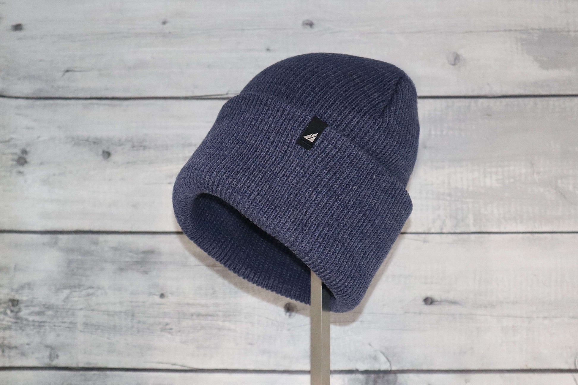 Adult Acrylic Cuff Hat – Soft Knit Beanie displayed on a wooden background, showcasing its cozy knit texture and shape.