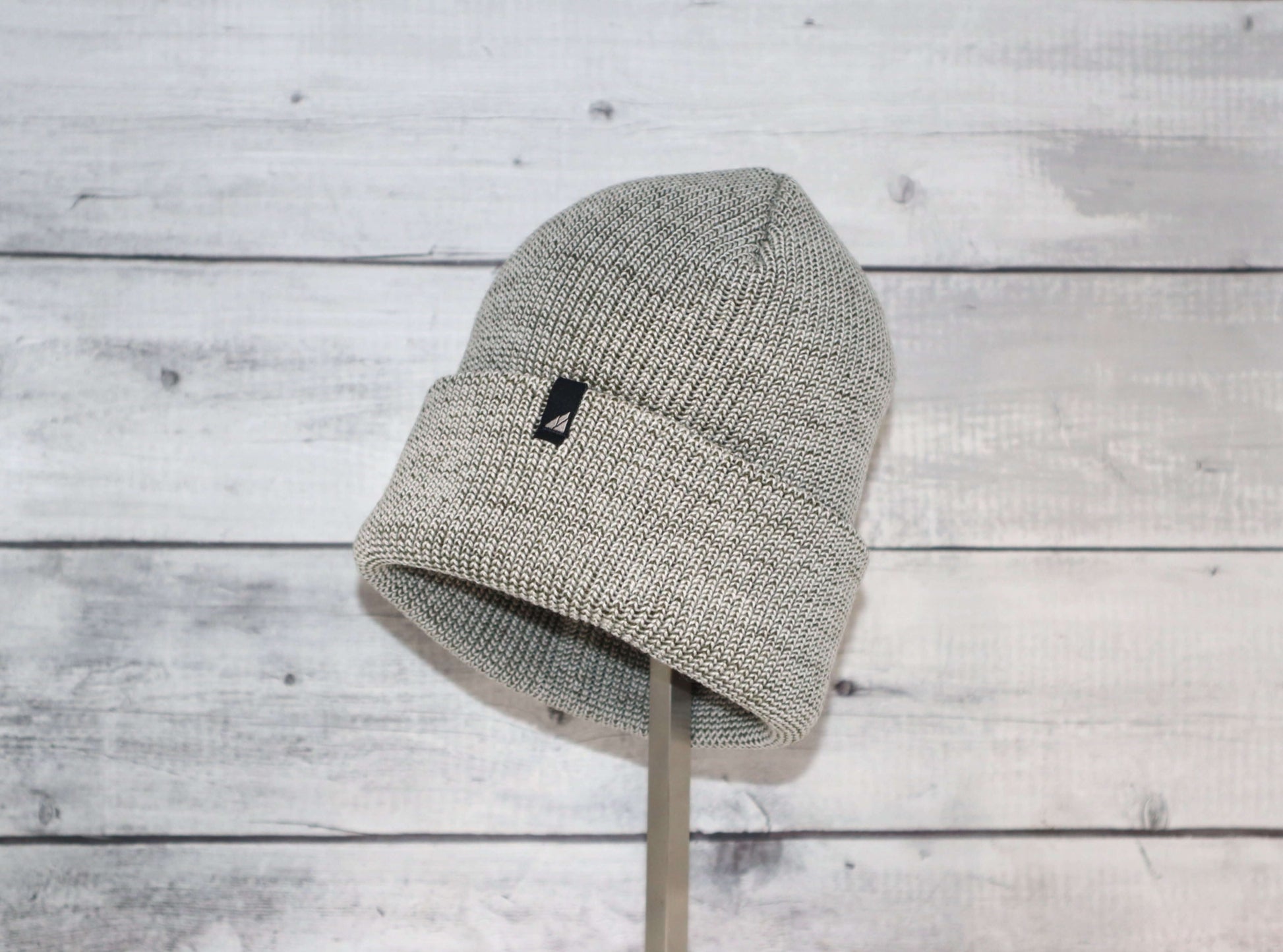 Adult Acrylic Cuff Hat – Soft Knit Beanie displayed on a stand against a wooden background.