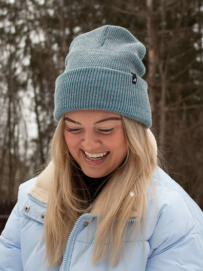 Adult Acrylic Cuff Hat – Soft Knit Beanie worn by a smiling woman in winter attire, outdoors with snow.