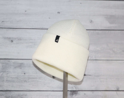 Adult Acrylic Cuff Hat – Soft Knit Beanie displayed on a stand against a wooden background.