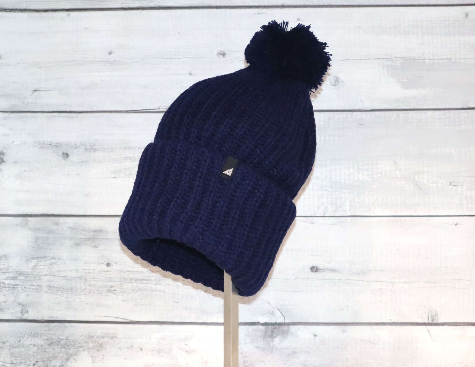 Adult Acrylic Ribbed Cuff Hat with Matching Pom – Cozy & Classic in navy color, featuring a playful pom and snug fit.